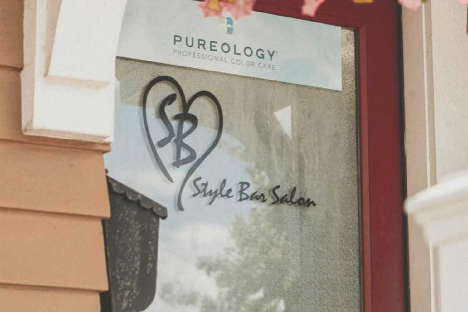 Entrance door of Style Bar Salon with Pureology sign above it.